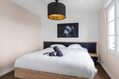- une chambre avec un lit blanc et une tête de lit noire dans l'établissement *DISNEYLAND-SERRIS* 4 pers Cosy apartment, à Serris