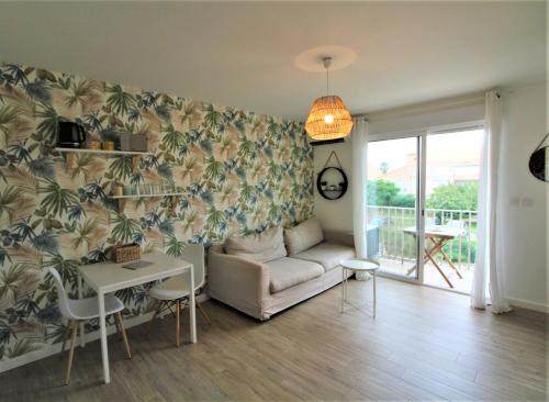 un salon avec un canapé et une table dans l'établissement Studio climatisé tout confort à 2 pas de la mer avec parking privé, à Palavas-les-Flots