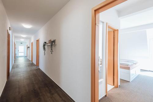a hallway with white walls and wooden floors at XXL Ferienhaus Goldberger See - Sauna - 16 Personen in Goldberg