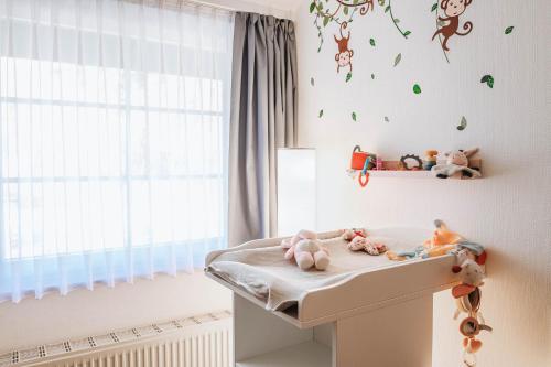 a childs room with a crib with toys and a window at XXL Ferienhaus Goldberger See - Sauna - 16 Personen in Goldberg