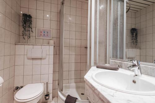 a bathroom with a sink and a toilet and a tub at XXL Ferienhaus Goldberger See - Sauna - 16 Personen in Goldberg