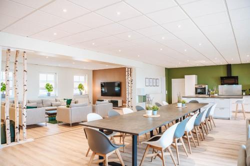 a dining room and living room with a table and chairs at XXL Ferienhaus Goldberger See - Sauna - 16 Personen in Goldberg