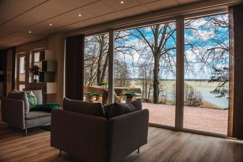 a living room with a large window with a view at XXL Ferienhaus Goldberger See - Sauna - 16 Personen in Goldberg