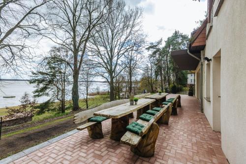 a group of wooden benches sitting next to a building at XXL Ferienhaus Goldberger See - Sauna - 16 Personen in Goldberg