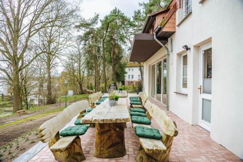 a wooden table with green pillows on a patio at XXL Ferienhaus Goldberger See - Sauna - 16 Personen in Goldberg