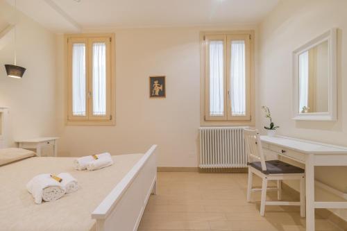 ein weißes Schlafzimmer mit einem Bett und einem Schreibtisch in der Unterkunft Casa Masa close to @S.Lucia Train Station in Venedig