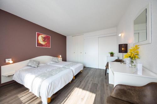 a bedroom with a large white bed and a desk at ULVF Le Domaine de l'Olivaie in Gilette