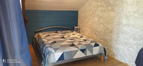 een klein bed in een kamer met een blauwe muur bij Gîte Le Roman d'Alleyrac (ciel bleu) in Alleyrac