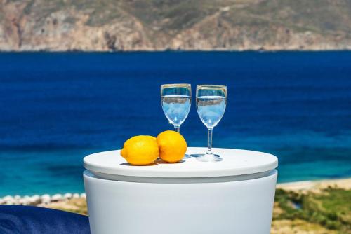 two glasses of water and lemons on a table near the ocean at Villa ANASA private Pool & Jacuzzi 8pax at Panormos in Panormos Mykonos