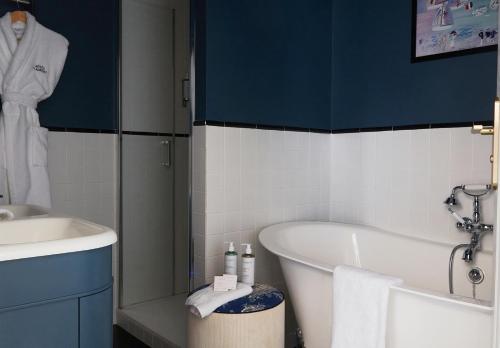 a bathroom with a tub and a sink at Le Flaubert in Trouville-sur-Mer