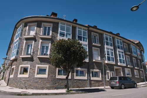 a building with a car parked in front of it at Pensión A Solaina 3 in O Pedrouzo