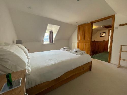 - une chambre avec un lit doté de draps blancs et une fenêtre dans l'établissement Hawthorn Dene, à Torrin