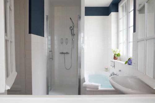 a bathroom with a shower and a tub and a sink at Le Flaubert in Trouville-sur-Mer