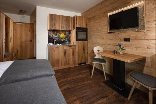 a bedroom with a bed and a desk and a tv at Wassererlehen in Bischofswiesen