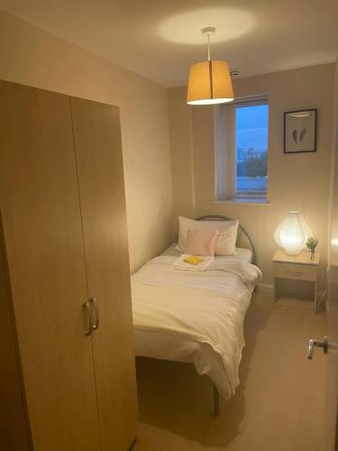 een kleine slaapkamer met een bed en een raam bij 3 Bedroom Beautiful Apartment in Manchester