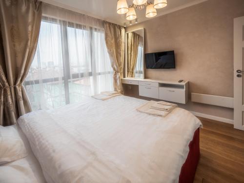 a bedroom with a large bed with a large window at The Boulevard Luxury Apartment in Sofia