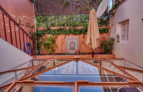 a patio with an umbrella and a swimming pool at Riad Palmi magnifique Riad centre ville - 6px in Agadir