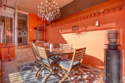 une salle à manger aux murs orange avec une table et des chaises dans l'établissement Riad Palmi magnifique Riad centre ville - 6px, à Agadir