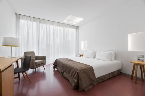 a hotel room with a bed and a desk and chair at Pousada Meaño in Meaño