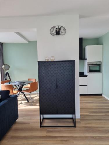 a living room with a couch and a table at Vakantie vieren aan het Sneekermeer in Offingawier