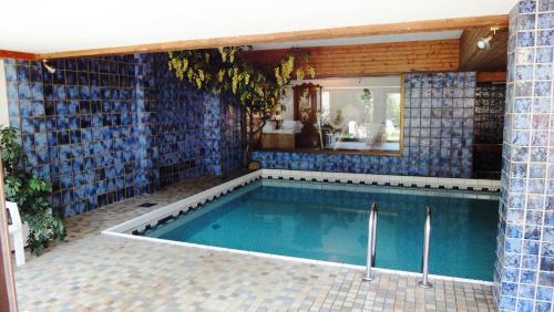 a swimming pool with a blue tiled wall at Bergsteiger-Zimmer Pension Obermair in Mayrhofen