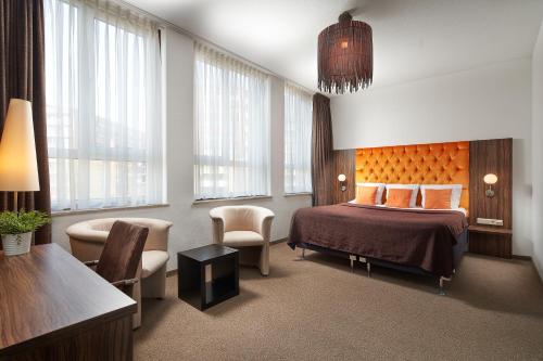 une chambre d'hôtel avec un lit et une chaise dans l'établissement Hotel La Reine, à Eindhoven