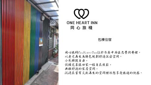a building with a rainbow wall and a one heart inn sign at One Heart Inn in Tainan