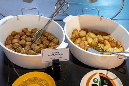 two bowls of food on a table with spoons at Novotel Paris Vaugirard Montparnasse in Paris