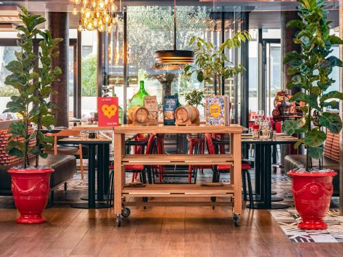 a book cart in a restaurant with potted plants at Novotel Paris Vaugirard Montparnasse in Paris