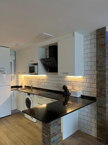 a kitchen with white cabinets and a washer and dryer at Hany apartment Ducado 11-C in Benidorm