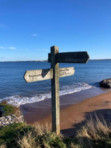 a wooden cross on the beach next to the ocean at Balmridge House, Loch Ness, Bed & Breakfast in Drumnadrochit