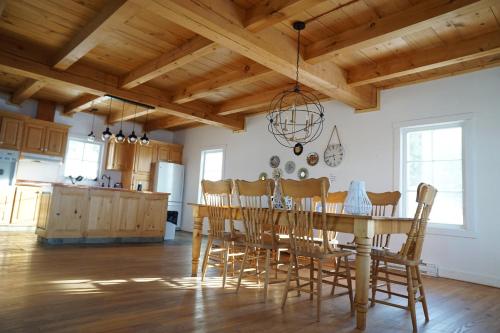 a kitchen and dining room with a wooden table and chairs at la belle vue des battures Saguenay Labaie ,qc in Saguenay