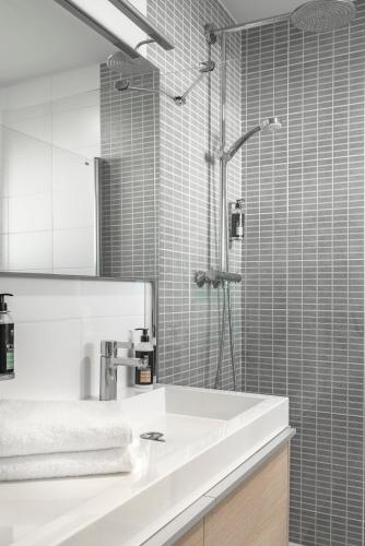 a bathroom with a white sink and a shower at Hôtel la Magnaneraie in Villeneuve-lès-Avignon
