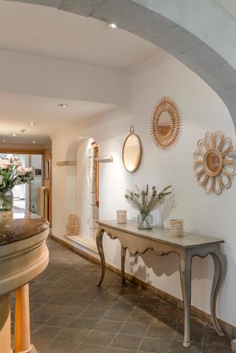 a room with a table and a mirror on the wall at Hôtel la Magnaneraie in Villeneuve-lès-Avignon