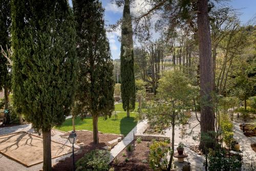 a view of a park with trees and grass at Hôtel la Magnaneraie in Villeneuve-lès-Avignon