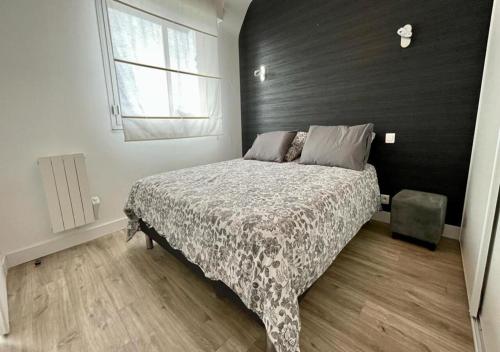 ein Schlafzimmer mit einem Bett mit einer schwarzen Wand in der Unterkunft LE PADDAIR in Quiberon