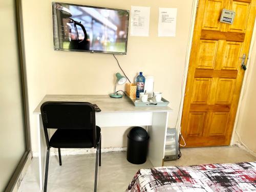 a bedroom with a desk with a chair and a mirror at SapzRes at Klerksdorp in Klerksdorp