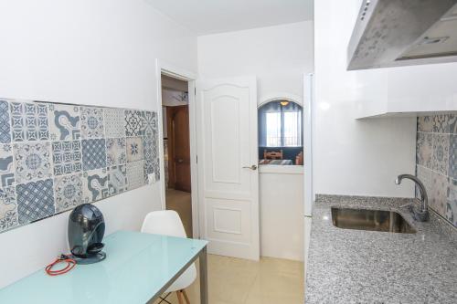 a kitchen with blue and white tiles on the wall at Miramar - Goya in Carboneras