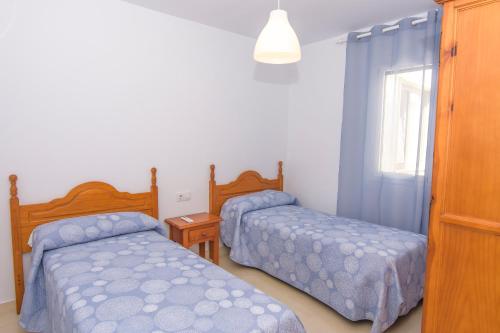a bedroom with two beds and a window at Miramar - Goya in Carboneras