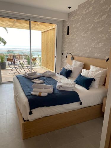 a bedroom with a large bed with towels on it at Hôtel L'Albatros in Saint-Trojan-les-Bains