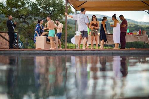 a group of people standing around a pool of water at Le Case Del Merlo Turismo Rurale in Milo