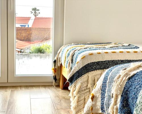 a bedroom with two beds and a window at Ocean House Alentejo in Porto Covo