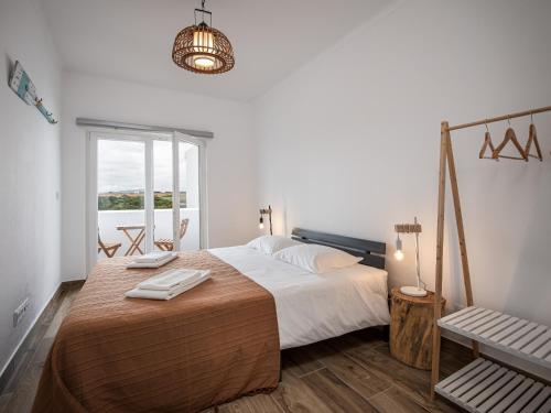 Un dormitorio con una cama grande y una ventana en Ocean House Alentejo, en Porto Covo