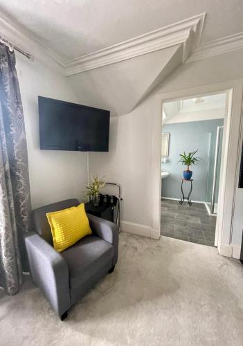 a living room with a couch and a yellow pillow at Crown House in Inverness