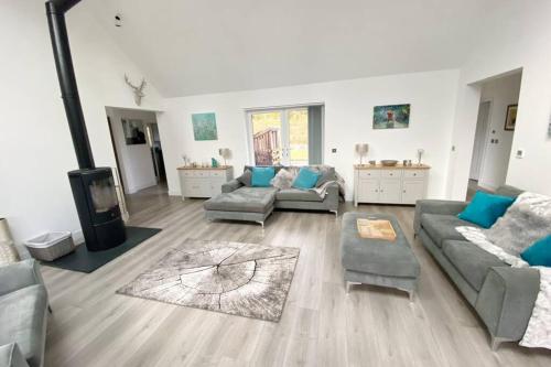 uma sala de estar com dois sofás e uma televisão em Camden House luxury home near Ben Nevis Scotland Highlands em Fort William
