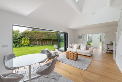 uma sala de estar com uma mesa branca e cadeiras em Beautiful countryside home, 10min drive to Bath em Limpley Stoke