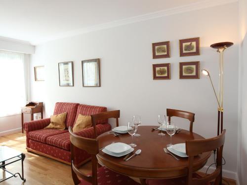 a living room with a table and a red couch at Apartamento Ondarreta in San Sebastián