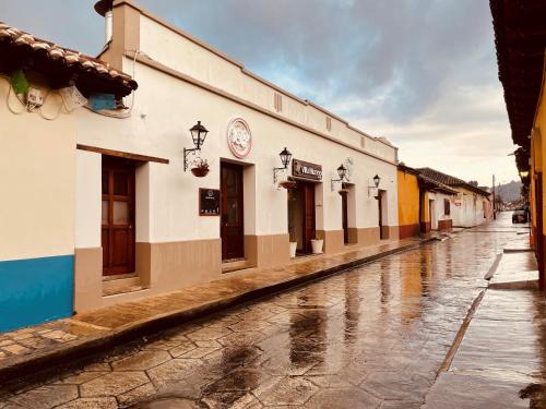 an empty street in the rain with a building at Hotel Villa Murano in San Cristóbal de Las Casas