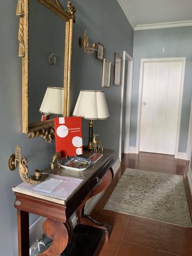 a room with a table with a mirror and a lamp at Casa Delft in Furnas