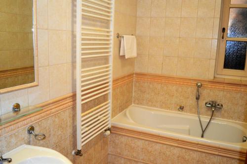 a bathroom with a bath tub and a sink at Hotel Renesance Krasna Kralovna in Karlovy Vary
